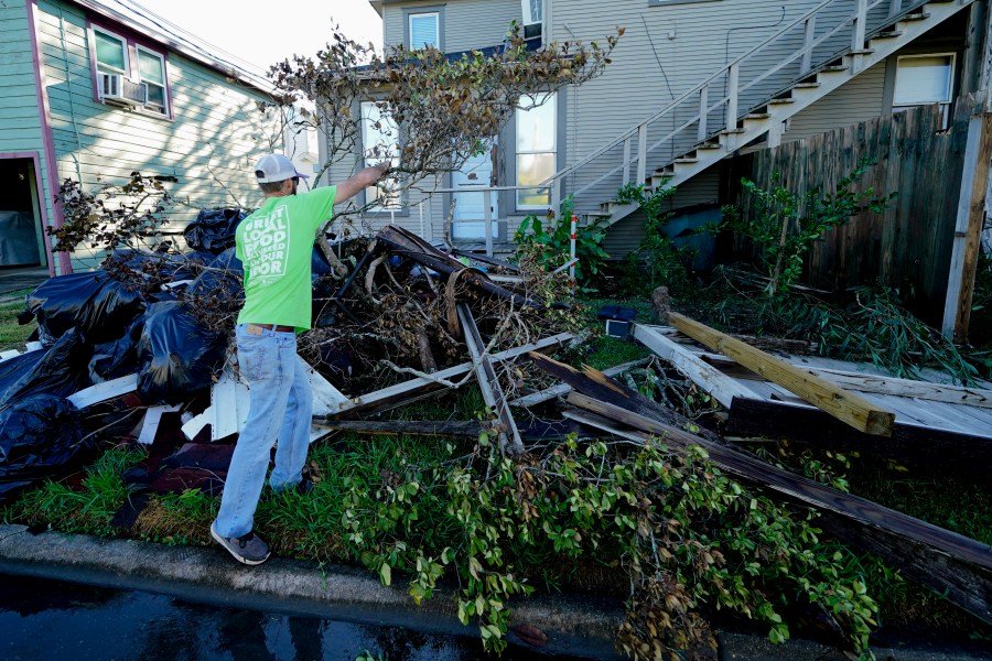 Caleb Cormier moves debris after Hurricane Delta moved through, Saturday, Oct. 10, 2020, in Lake Charles, La. Delta hit as a Category 2 hurricane with top winds of 100 mph (155 kph) before rapidly weakening over land. (AP Photo/Gerald Herbert)