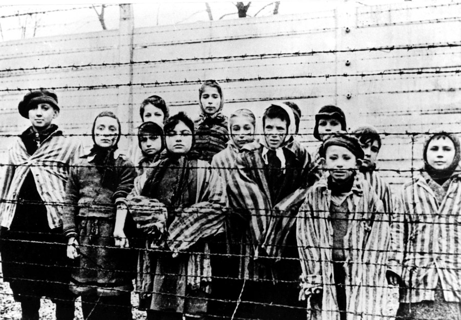 A picture taken just after the liberation by the Soviet army in January, 1945, shows a group of children wearing concentration camp uniforms at the time behind barbed wire fencing in the Oswiecim (Auschwitz) nazi concentration camp. (AP Photo/CAF pap, file)