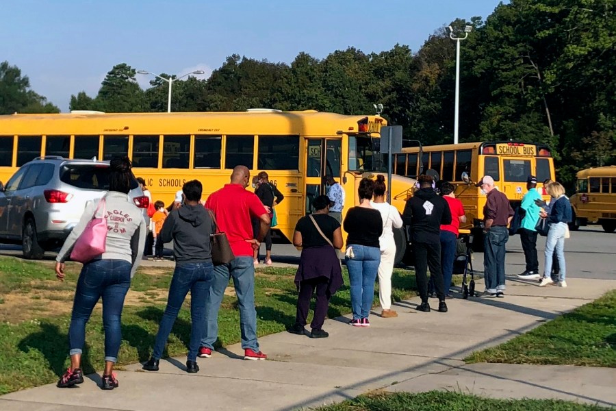 In this Thursday, Oct. 15, 2020, photo voters line up at Mallard Creek High School during the first day of in-person voting ahead of the Nov. 3 elections in Charlotte, N.C. (Laurie Kellman/AP Photo)