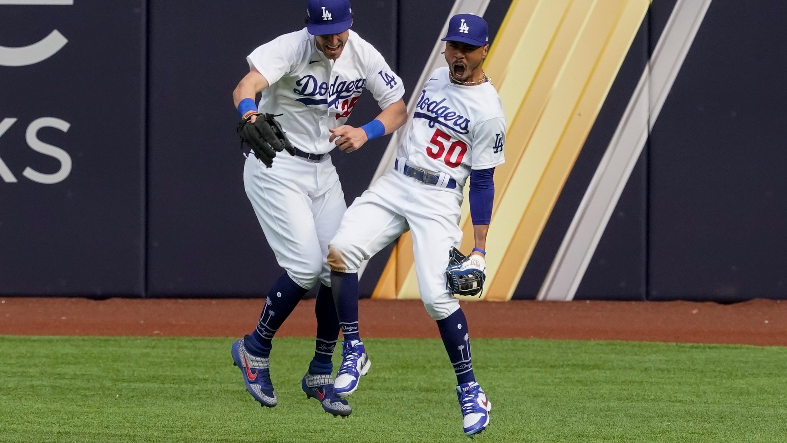 Los Angeles Dodgers right fielder Mookie Betts celebrates with center fielder Cody Bellinger after robbing Atlanta Braves' Marcell Ozuna of a home during the fifth inning in Game 6 of a baseball National League Championship Series Saturday, Oct. 17, 2020, in Arlington, Texas. (AP Photo/Tony Gutierrez)