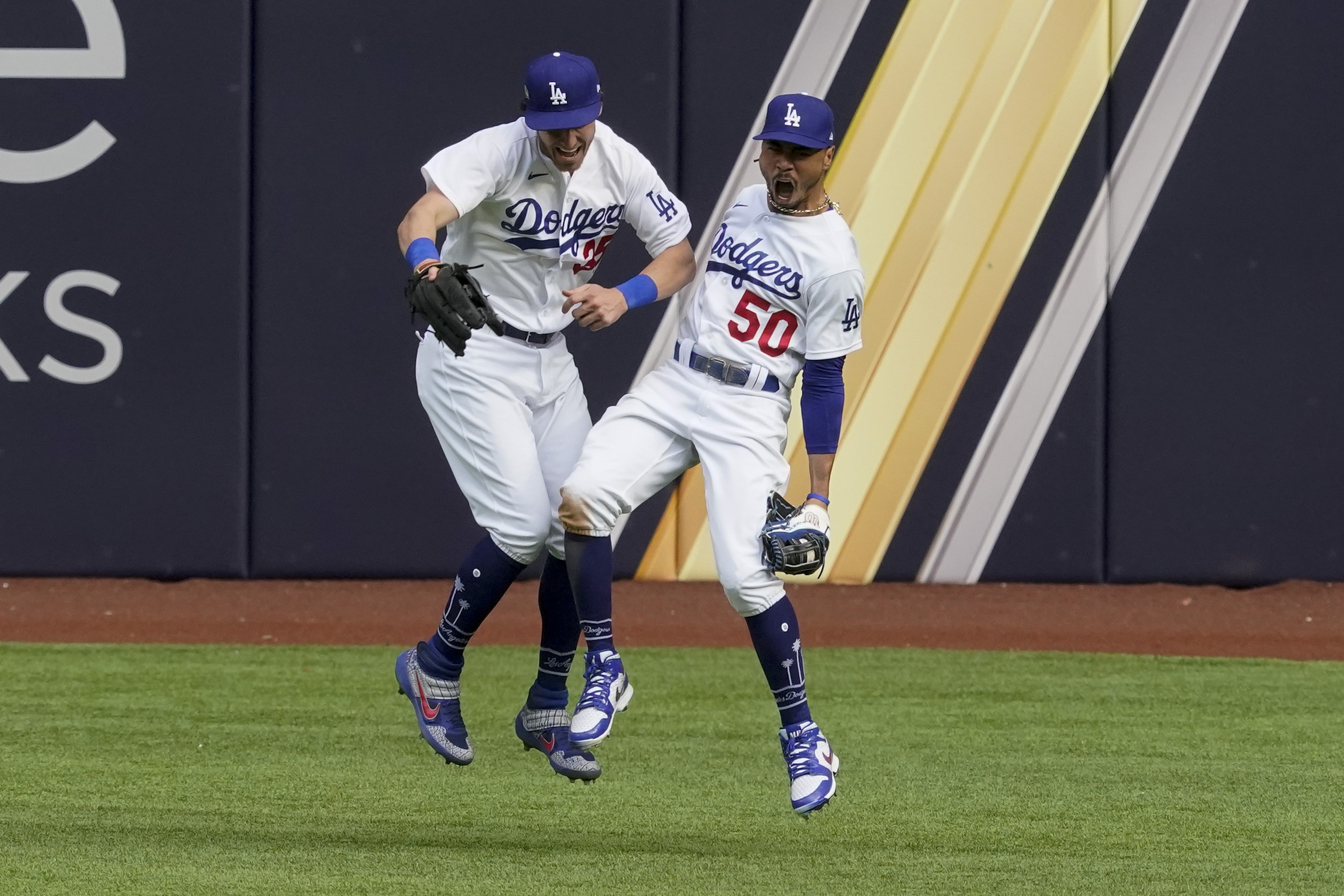 Los Angeles Dodgers right fielder Mookie Betts celebrates with center fielder Cody Bellinger after robbing Atlanta Braves' Marcell Ozuna of a home during the fifth inning in Game 6 of a baseball National League Championship Series Saturday, Oct. 17, 2020, in Arlington, Texas. (AP Photo/Tony Gutierrez)