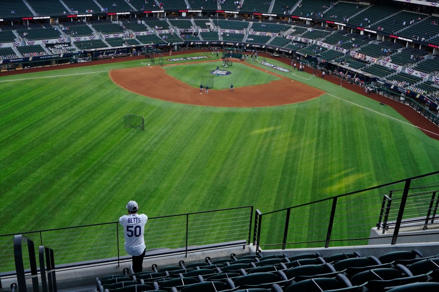 A fan watches batting practice from center field before Game 1 of the baseball World Series between the Los Angeles Dodgers and the Tampa Bay Rays on Oct. 20, 2020, in Arlington, Texas.(AP Photo/Sue Ogrocki)