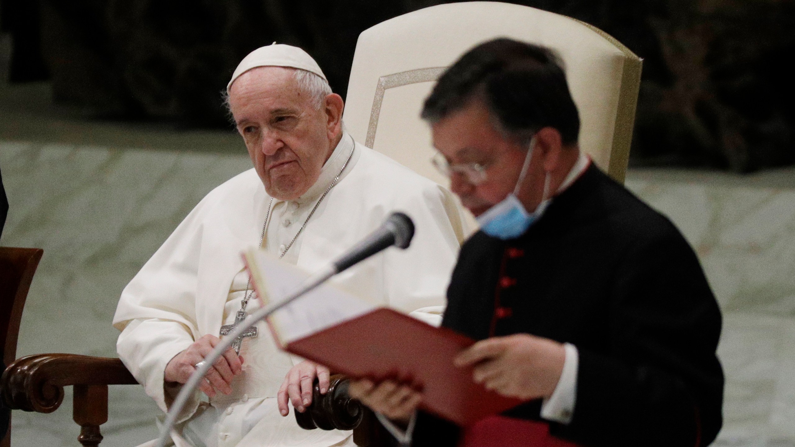 Pope Francis listens to a priests introducing the group of faithful attending the weekly general audience in the Paul VI hall at the Vatican on Oct. 21, 2020. (Gregorio Borgia/Associated Press)