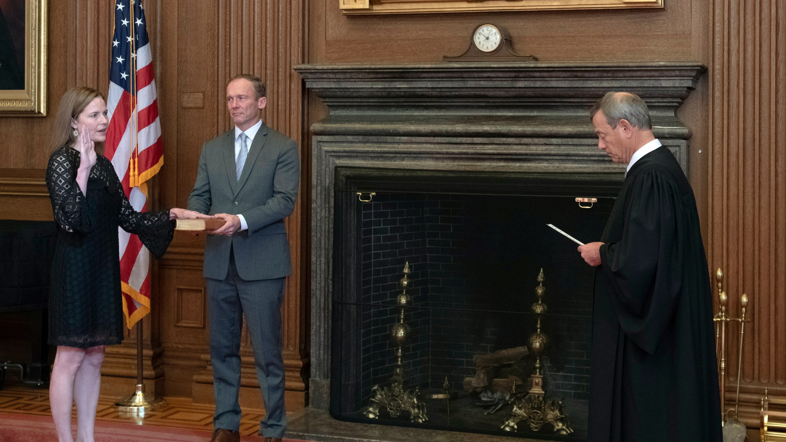 In this image provided by the Collection of the Supreme Court of the United States, Chief Justice John G. Roberts, Jr., right, administers the Judicial Oath to Judge Amy Coney Barrett in the East Conference Room of the Supreme Court Building, Tuesday, Oct. 27, 2020, in Washington as Judge Barrett's husband, Jesse M. Barrett, holds the Bible. (Fred Schilling/Collection of the Supreme Court of the United States via AP)