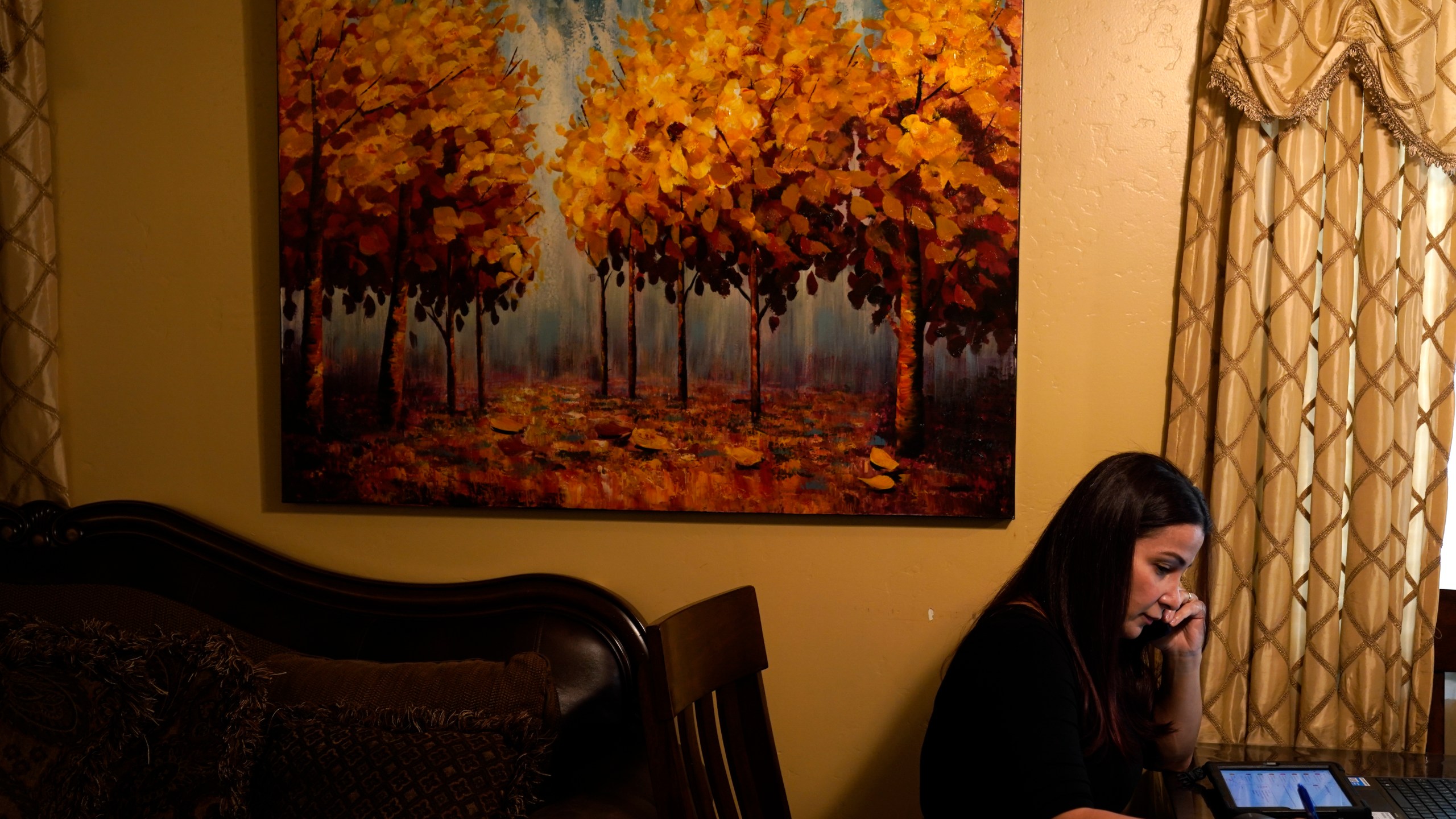 Iraqi immigrant Ethar Kakoz, a coronavirus contact tracer, makes calls Wednesday, Oct. 28, 2020, in El Cajon. (AP Photo/Gregory Bull)