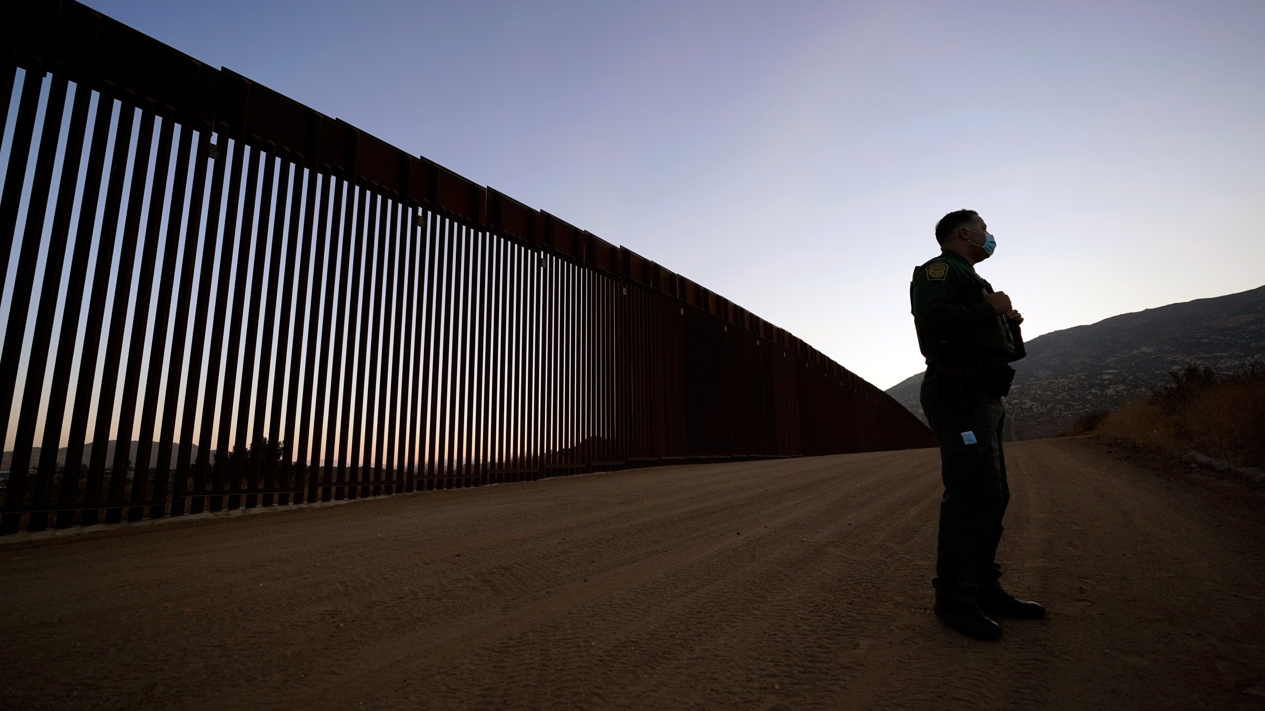 Border Patrol agent Justin Castrejon speaks in front of newly replaced border wall sections on Sept. 24, 2020, near Tecate, Calif. (AP Photo/Gregory Bull)