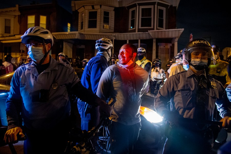 A person is handcuffed and detained by police in Philadelphia on Oct. 28, 2020, two days after Walter Wallace Jr. was killed by police officers. (Tom Gralish/The Philadelphia Inquirer via Associated Press)