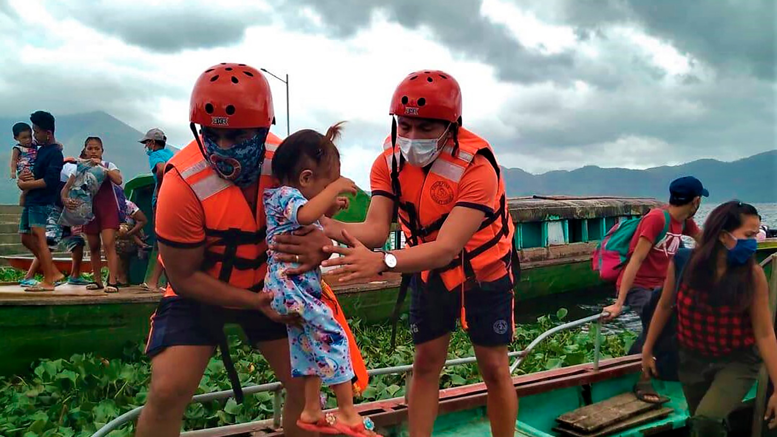 In this photo provided by the Philippine Coast Guard, members of the Philippine Coast Guard carry a child as they are evacuated to safer ground in Camarines Sur province, eastern Philippines on Saturday Oct. 31, 2020 as they prepare for typhoon Goni. (Philippine Coast Guard via AP)