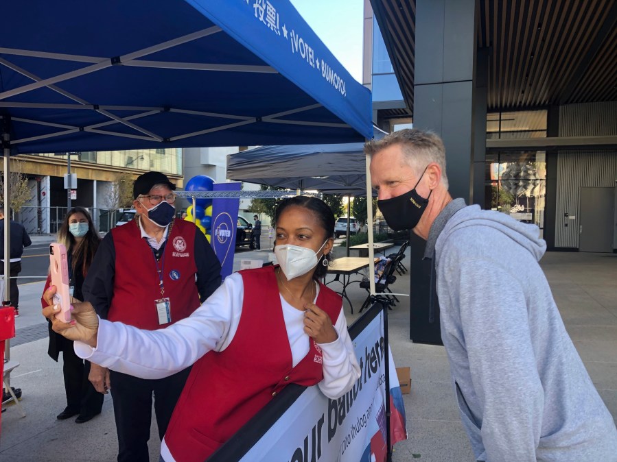 Golden State Warriors coach Steve Kerr poses for a selfie with voting worker Jujuana Williams of Oakland on Saturday, Oct. 31, in San Francisco. (Janie McCauley/AP Photo)