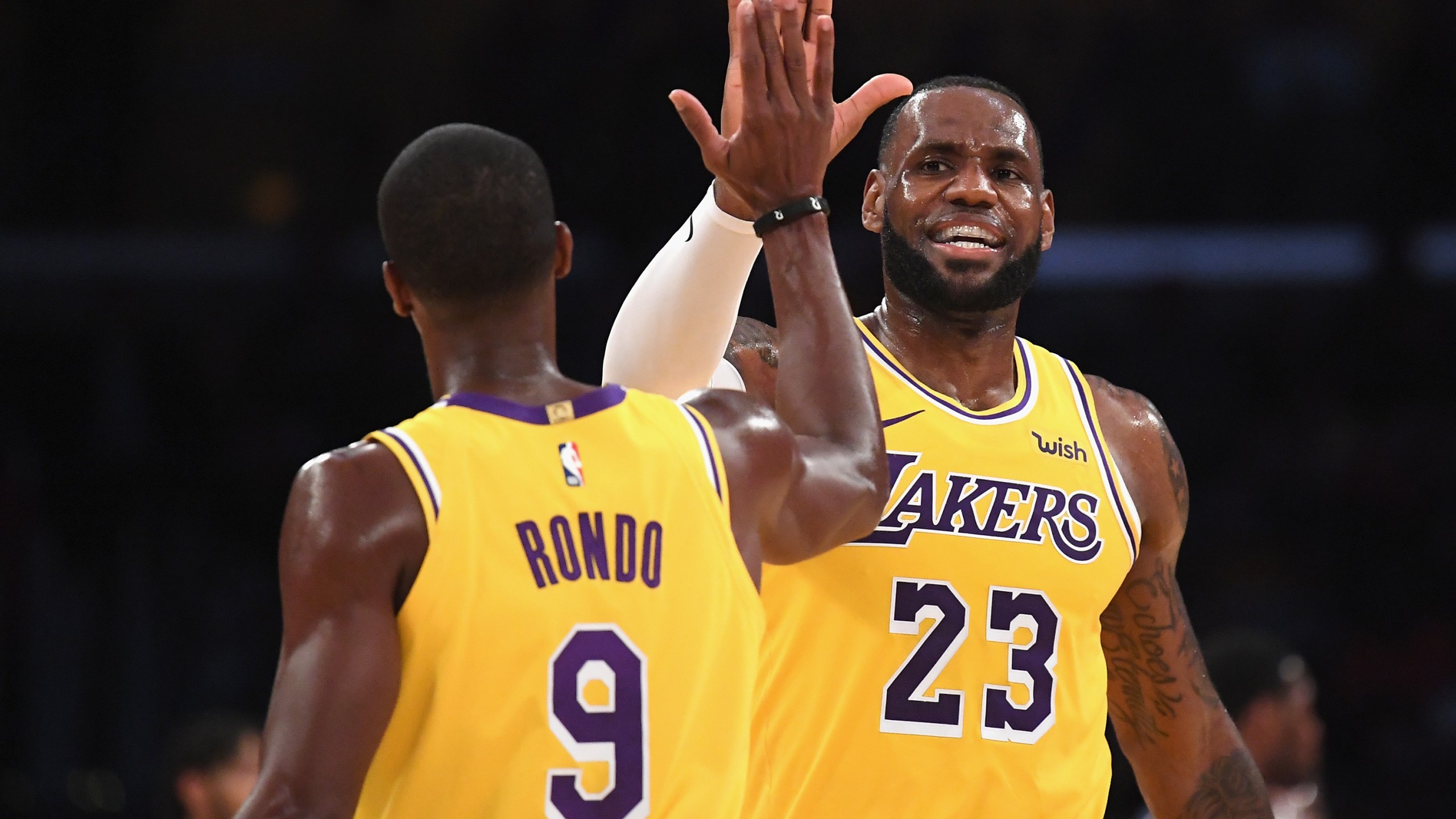 LeBron James of the Los Angeles Lakers high fives Rajon Rondo during a preseason game against the Denver Nuggets at Staples Center on Oct. 2, 2018. (Harry How / Getty Images)