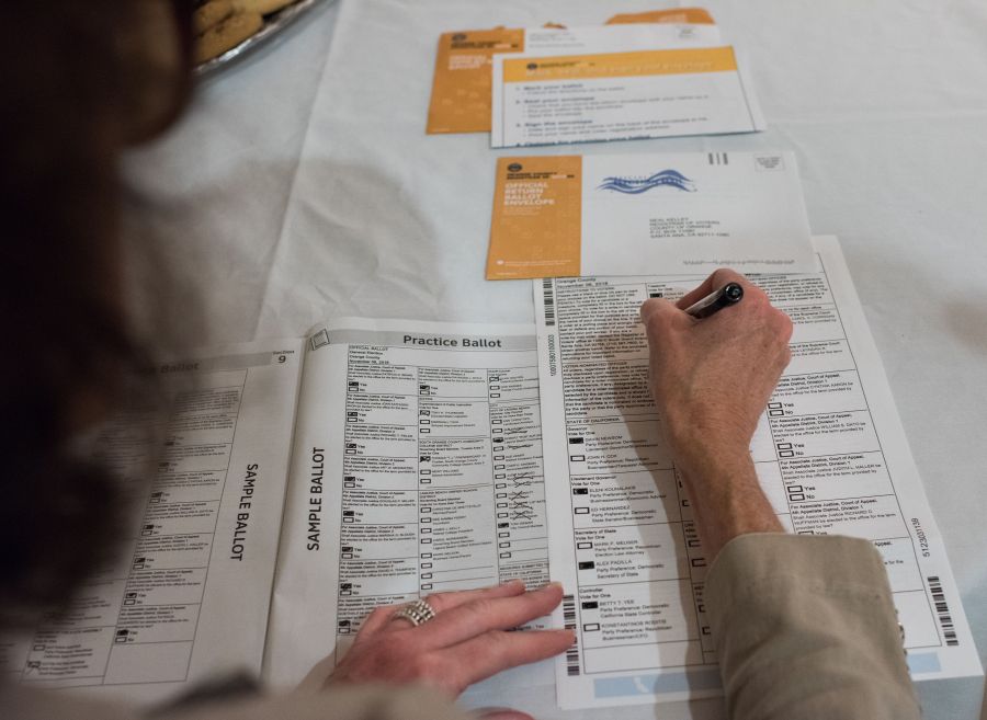 A voter completes her mail-in ballot at a ballot party at a private residence in Laguna Niguel on Oct. 24, 2018. (ROBYN BECK/AFP via Getty Images)