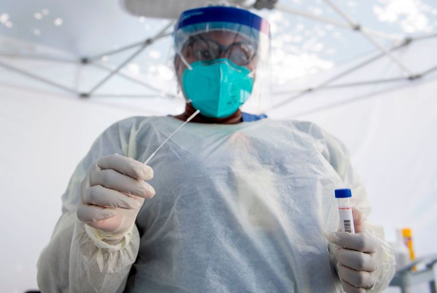 A health worker takes a nasal swab sample at a COVID-19 testing site at St. John's Well Child and Family Center, amid the novel coronavirus pandemic in Los Angeles in July. (VALERIE MACON/AFP via Getty Images)