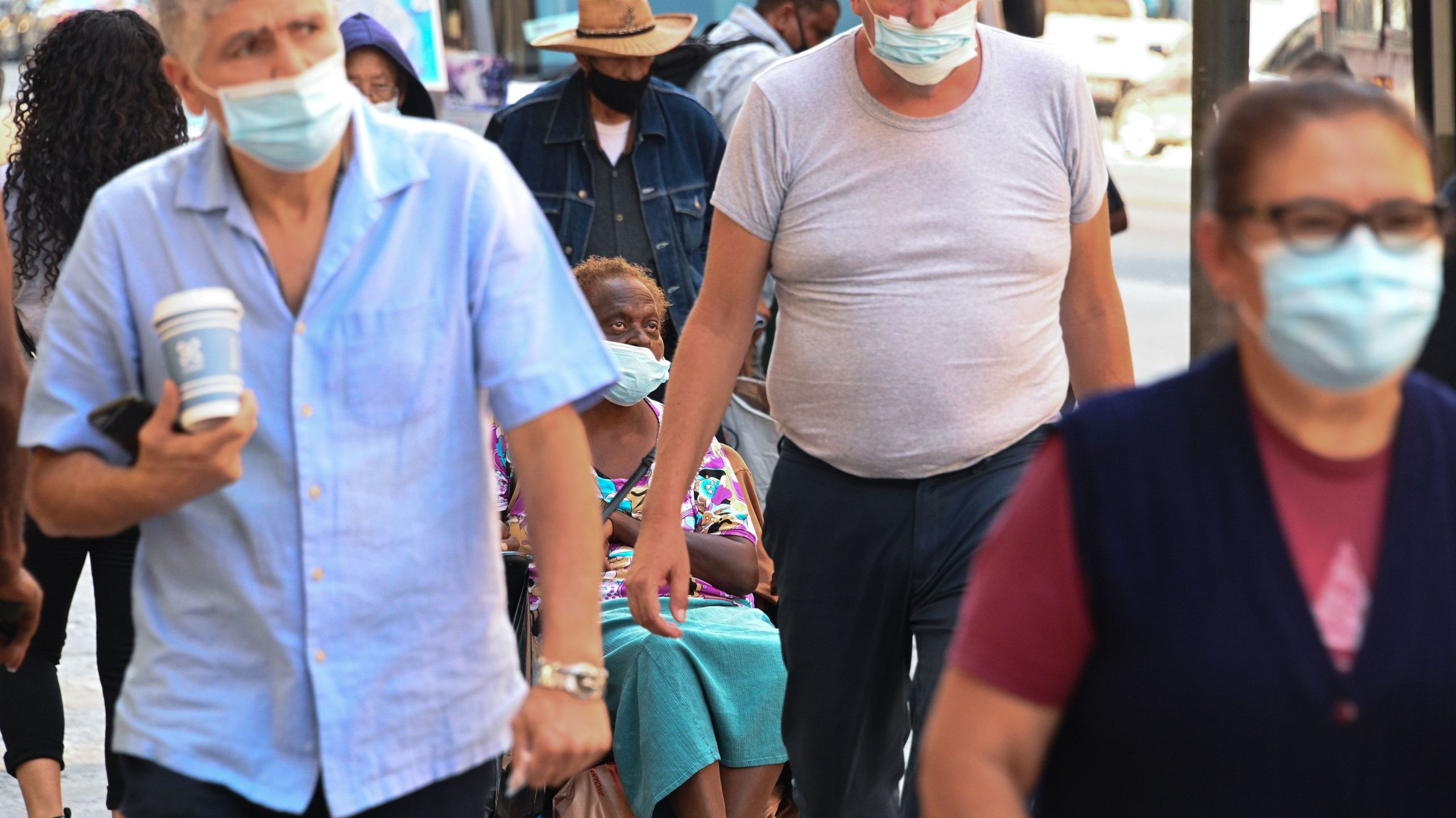 People wearing masks walk on a street in downtown Los Angeles on Oct. 2, 2020, amid the coronavirus COVID-19 pandemic. (ROBYN BECK/AFP via Getty Images)