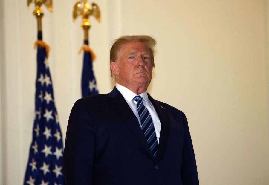 President Donald Trump looks out from the Truman Balcony upon his return to the White House from Walter Reed Medical Center, where he underwent treatment for COVID-19, in Washington, D.C., on Oct. 5, 2020. (NICHOLAS KAMM / AFP via Getty Images)