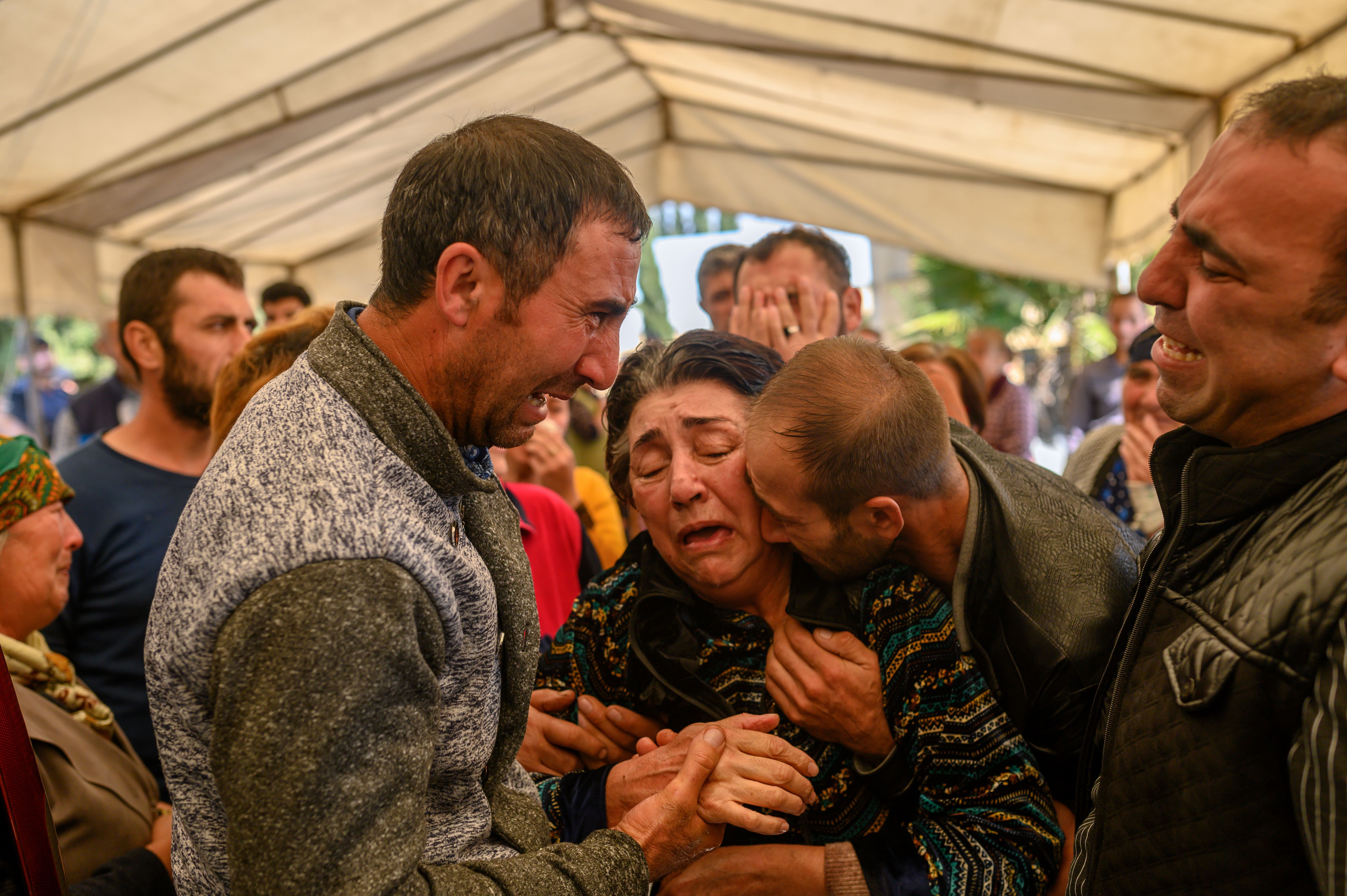 Relatives of Royal Sahnazarov, his wife Zuleyha Sahnazarova and their daughter Medine Sahnazorava, who were killed when a rocket hit their home, mourn during their funeral in the city of Ganja, Azerbaijan, on Oct. 17, 2020 during fighting over the breakaway region of Nagorno-Karabakh. (BULENT KILIC/AFP via Getty Images)