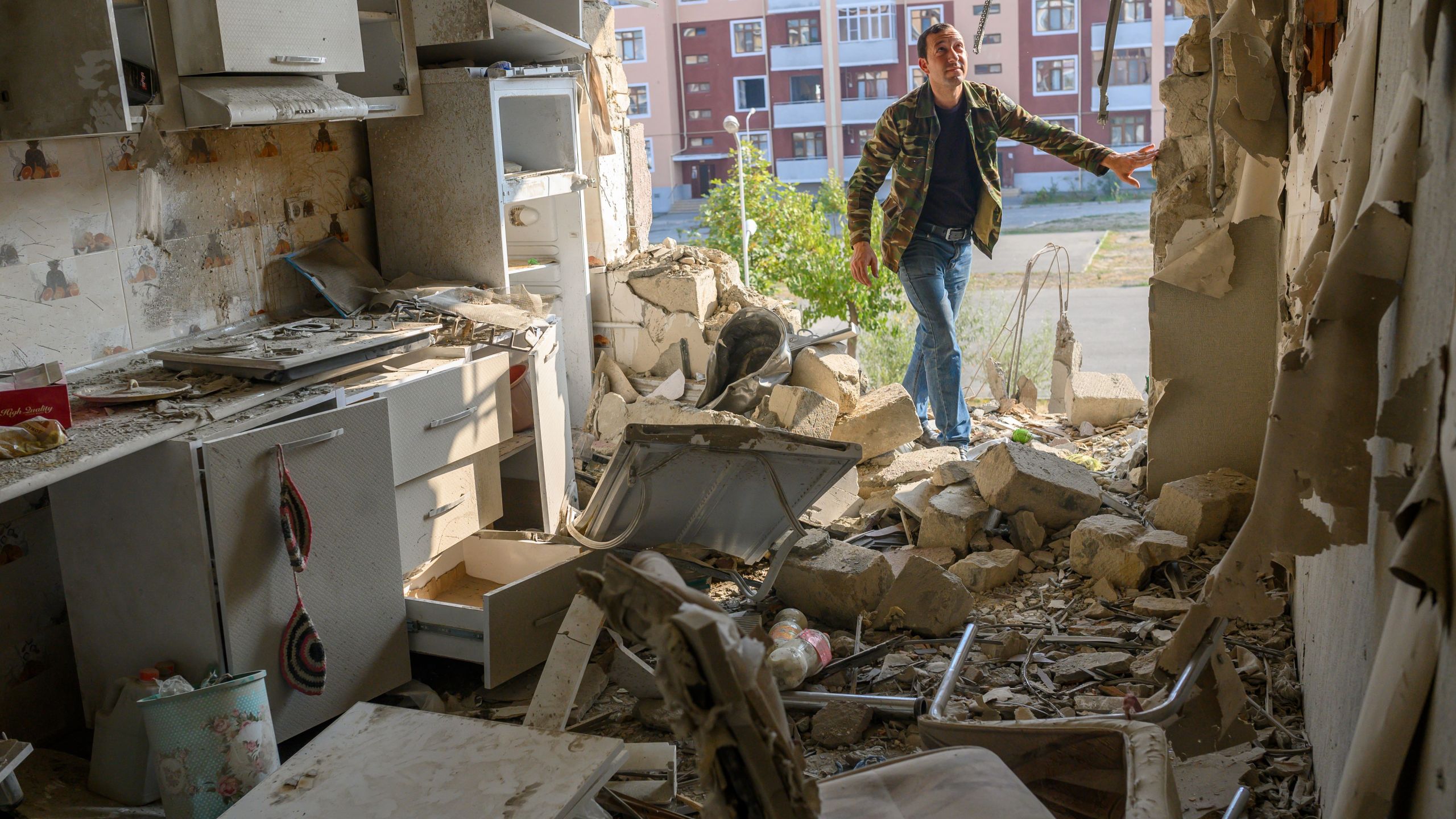 Movsumov Qowkar, 32, checks his neighbor's flat damaged during fighting over the breakaway region of Nagorno-Karabakh, in the city of Terter early on Oct. 18, 2020. The origins of a flareup in fighting over Nagorno-Karabakh that has now killed hundreds and threatens to involve regional powers Turkey and Russia are hotly contested and difficult to independently verify. Both sides accuse the other of striking first on September 27 over the ethnic Armenian region of Azerbaijan. (BULENT KILIC /AFP via Getty Images)