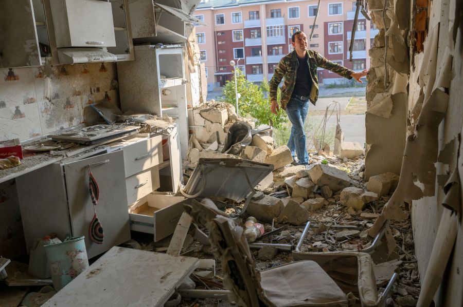 Movsumov Qowkar, 32, checks his neighbor's flat damaged during fighting over the breakaway region of Nagorno-Karabakh, in the city of Terter early on Oct. 18, 2020. The origins of a flareup in fighting over Nagorno-Karabakh that has now killed hundreds and threatens to involve regional powers Turkey and Russia are hotly contested and difficult to independently verify. Both sides accuse the other of striking first on September 27 over the ethnic Armenian region of Azerbaijan. (BULENT KILIC /AFP via Getty Images)