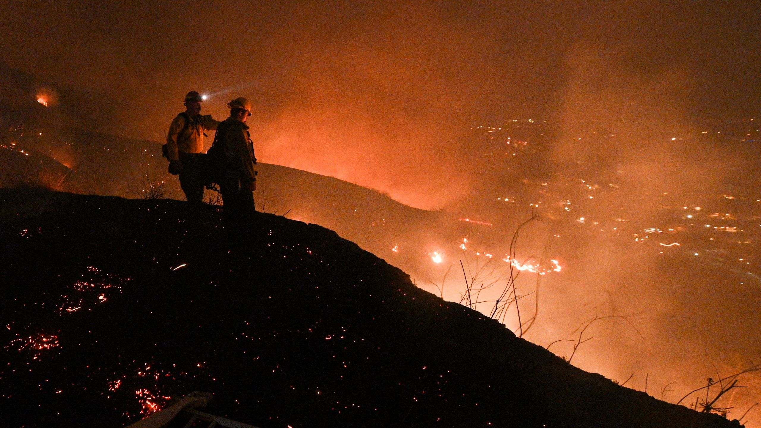 Firefighters look out over a burning hillside as they fight the Blue Ridge Fire in Yorba Linda on Oct. 26, 2020. (Robyn Beck / AFP / Getty Images)