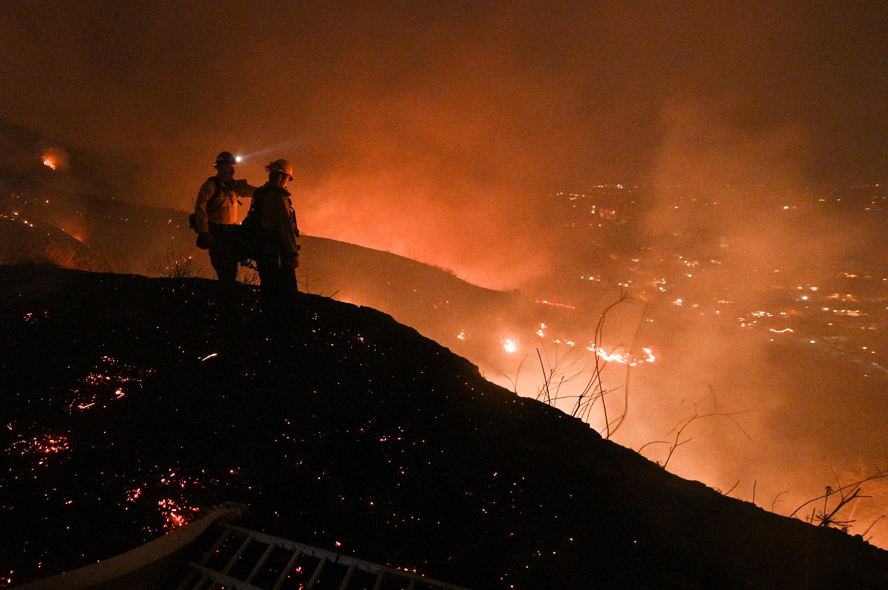 Firefighters look out over a burning hillside as they fight the Blue Ridge Fire in Yorba Linda on Oct. 26, 2020. (Robyn Beck / AFP / Getty Images)