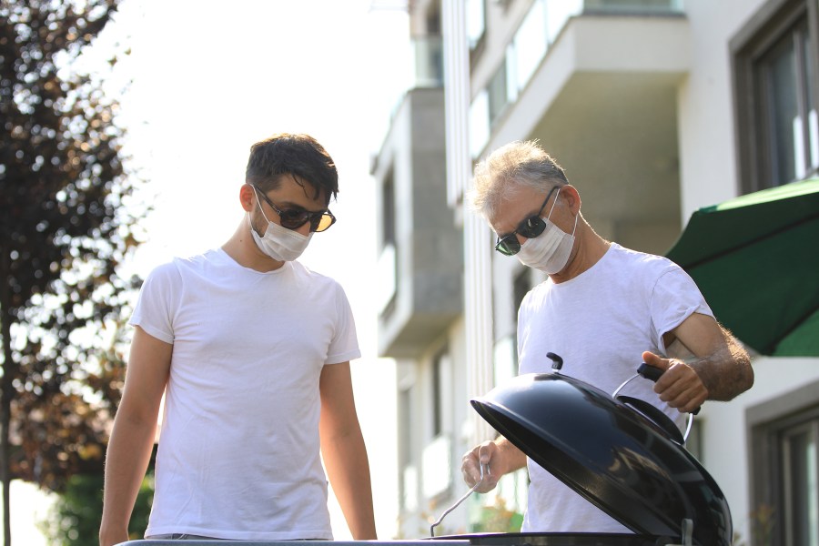 Father and son wearing surgical masks have a barbecue in the garden in this undated file photo. (Getty Images)