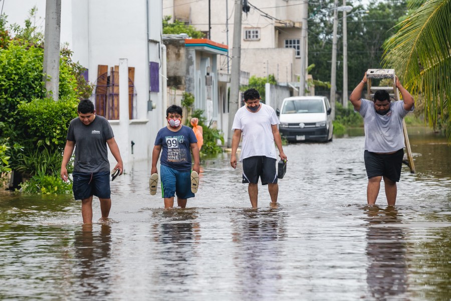 People walk on a flooded street after Hurricane Delta hit near Cozumel, Mexico, on Oct. 7, 2020. (Natalia Pescador / Getty Images)