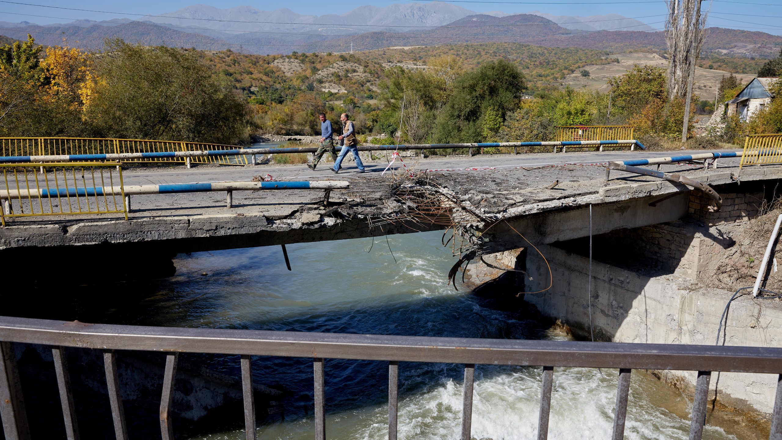 Two men walk across a bridge in Getavan, Nagorno-Karabakh, that was hit by an Azeri missile, on Oct. 14, 2020. (Alex McBride/Getty Images)