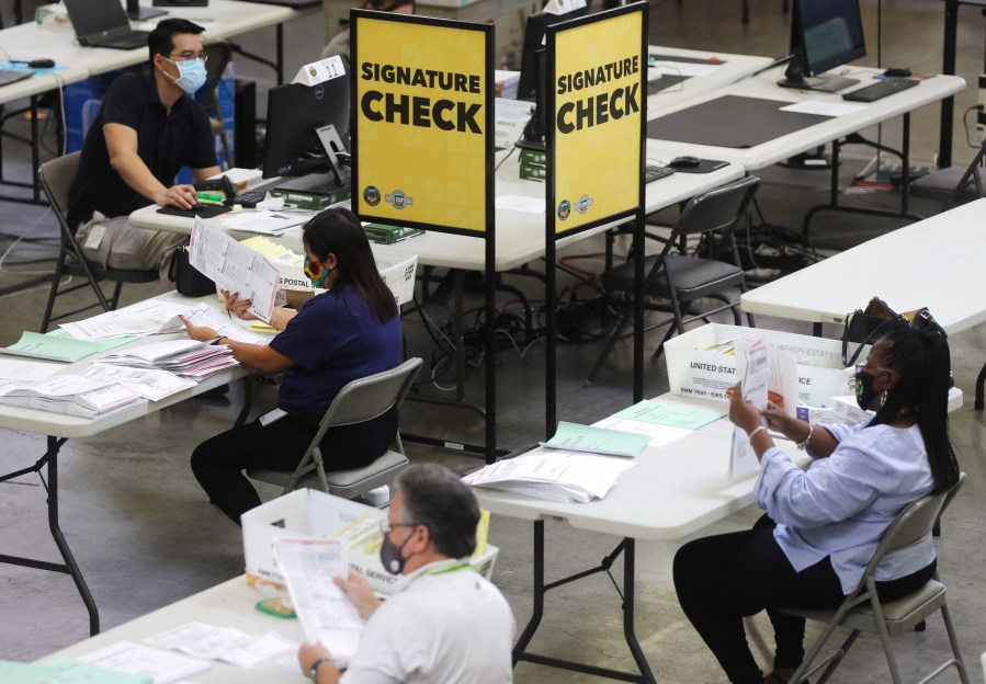 Election workers process mail-in ballots as a monitor displays a livestream of the process at the Orange County Registrar of Voters on October 19, 2020 in Santa Ana, California. (Mario Tama/Getty Images)