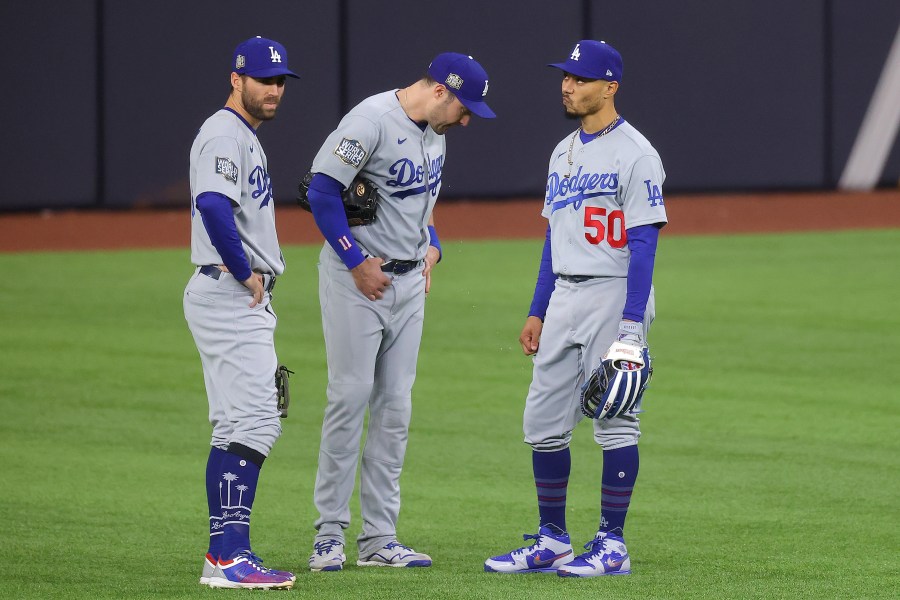 Chris Taylor, A.J. Pollock and Mookie Betts of the Los Angeles Dodgers talk during a pitching change against the Tampa Bay Rays during the seventh inning in Game Four of the 2020 MLB World Series at Globe Life Field on Oct. 24, 2020 in Arlington, Texas. (Ronald Martinez/Getty Images)