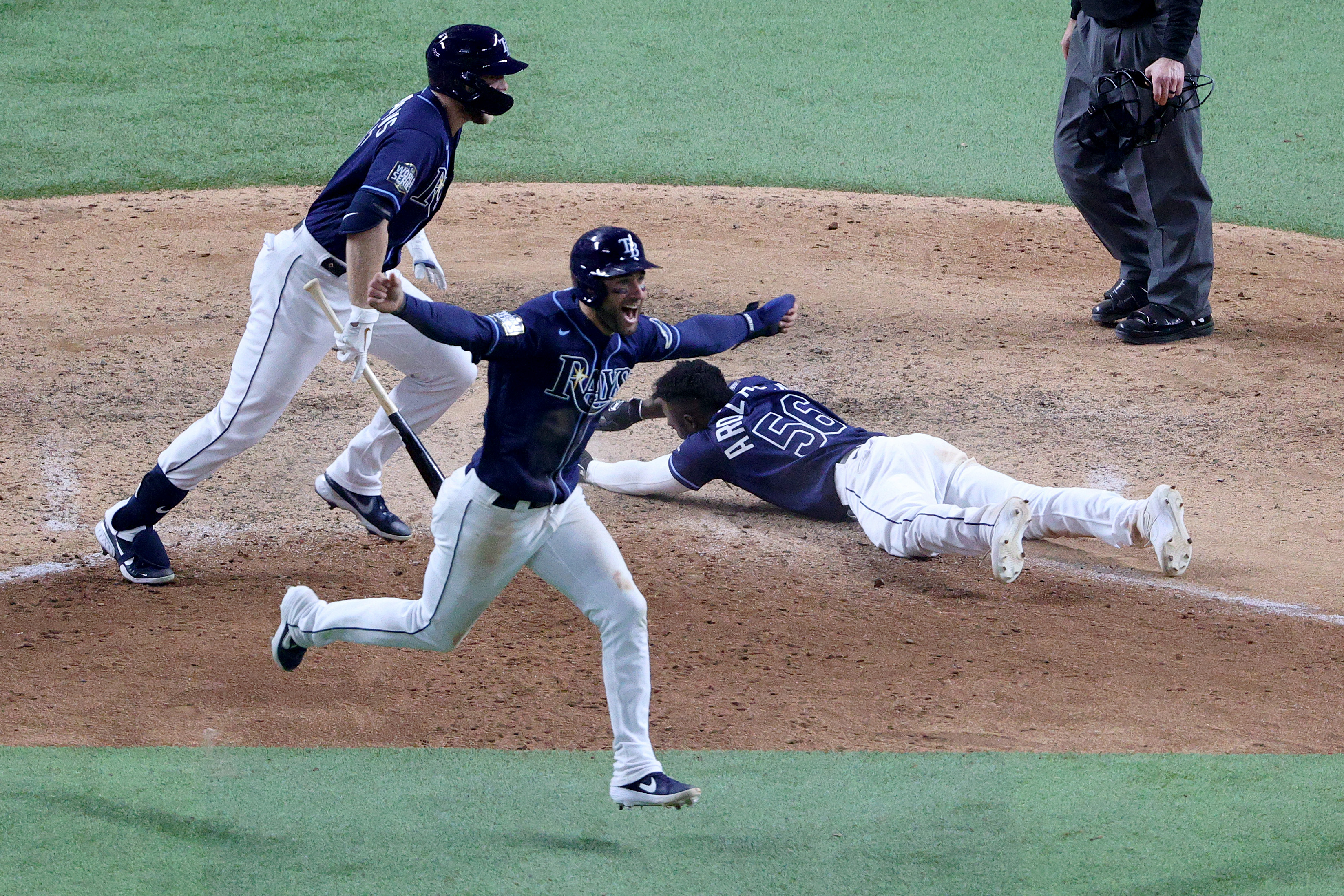 Randy Arozarena #56 of the Tampa Bay Rays slides into home plate during the ninth inning to score the game winning run to give his team the 8-7 victory as Kevin Kiermaier celebrates against the Los Angeles Dodgers in Game Four of the 2020 MLB World Series at Globe Life Field on Oct. 24, 2020, in Arlington, Texas. (Sean M. Haffey/Getty Images)