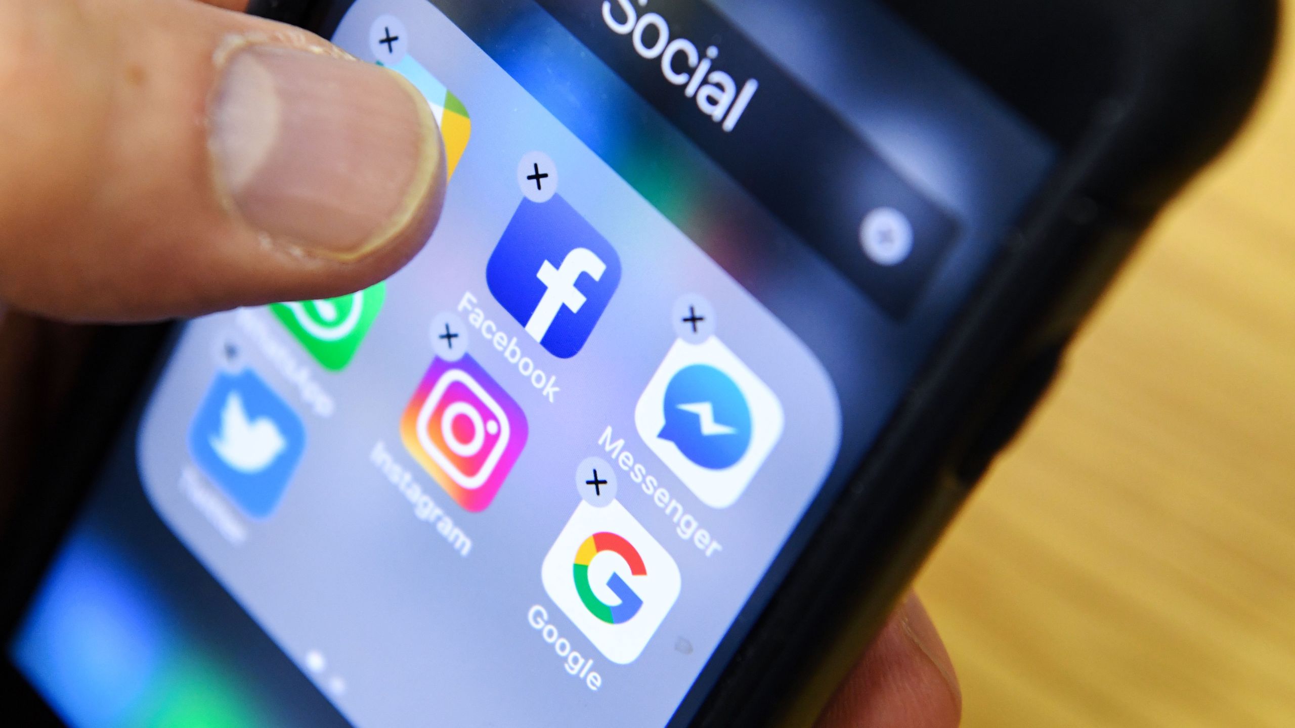 A man holds a smart phone with the icons for the social networking apps Facebook, Instagram and Twitter seen on the screen in Moscow on March 23, 2018. (KIRILL KUDRYAVTSEV/AFP via Getty Images)