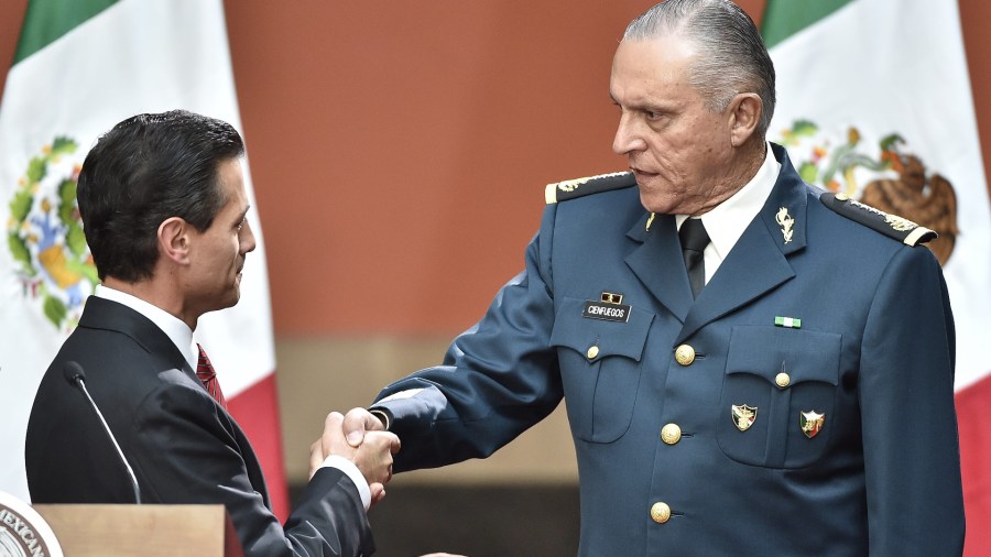 Mexican President Enrique Pena Nieto, left, congratulates Defense Secretary Gral. Salvador Cienfuegos Zepeda after his speech about recaptured drug baron Joaquin Guzman, aka "El Chapo", in Mexico City on Jan. 8, 2016. (Omar Toress /AFP / Getty Images)