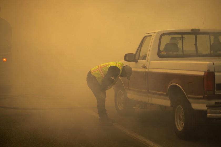 A water truck operator is overcome with smoke after running through the advancing Silverado fire in Orange County on Monday. Two fires in Orange County are contributing to “unhealthy” air in Southern California, the worst in the nation.(Allen J. Schaben / Los Angeles Times)