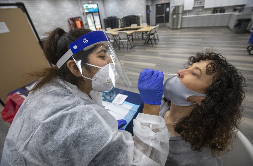 Laura Duggan is given a nasopharyngeal swab test to detect the coronavirus by Jessica Garcia at Arthur E. Wright Middle School in Calabasas.(Genaro Molina / Los Angeles Times)