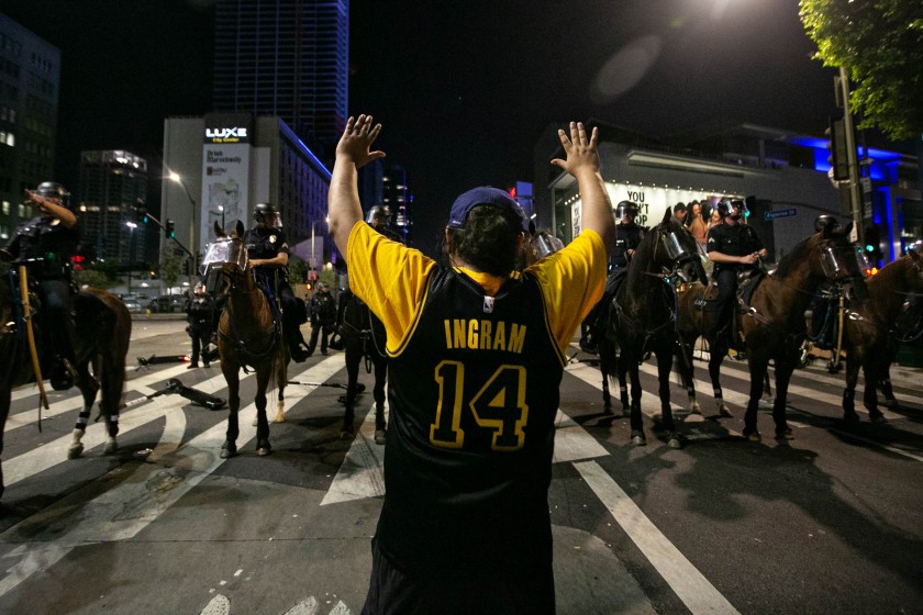 Los Angeles police officers clear the area near L.A. Live after declaring an unlawful assembly downtown following the Lakers’ championship win on Oct. 11, 2020.(Jason Armond / Los Angeles Times)