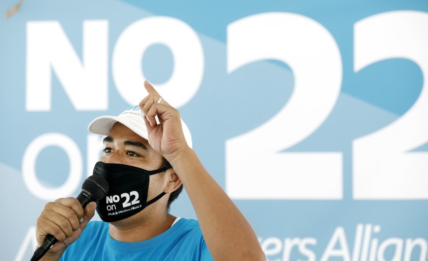 Felipe Caceres of Mobile Workers Alliance speaks at a news conference in Los Angeles against Proposition 22, the November ballot measure that would classify app-based drivers as independent contractors, exempting them from AB 5.(Christina House / Los Angeles Times)