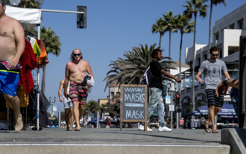 The day President Trump was diagnosed with COVID-19, many people still weren’t wearing masks near the pier in Huntington Beach. (Gina Ferazzi / Los Angeles Times)