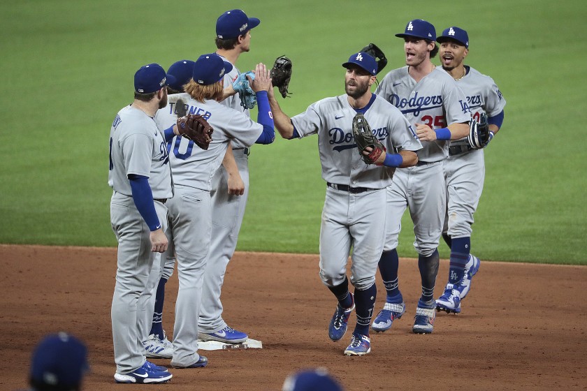 Dodgers players Chris Taylor, Cody Bellinger and Mookie Betts celebrate with teammates after their 12-3 win over the Padres in the NLDS on Oct. 8, 2020. (Robert Gauthier / Los Angeles Times)