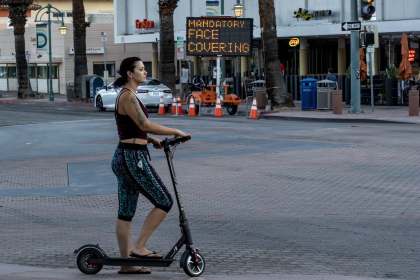 A woman travels on a scooter in downtown Palm Springs in Riverside County on July 16. (Gina Ferazzi/Los Angeles Times)