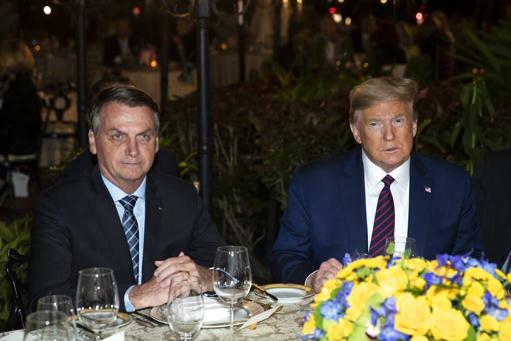 In this March 7, 2020, file photo President Donald Trump is seated before a dinner with Brazilian President Jair Bolsonaro, left, at Mar-a-Lago in Palm Beach, Fla. (AP Photo/Alex Brandon, File)