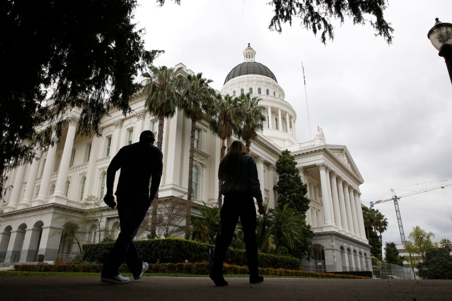 People walk near the state Capitol in Sacramento on March 18, 2020. (Rich Pedroncelli / Associated Press)