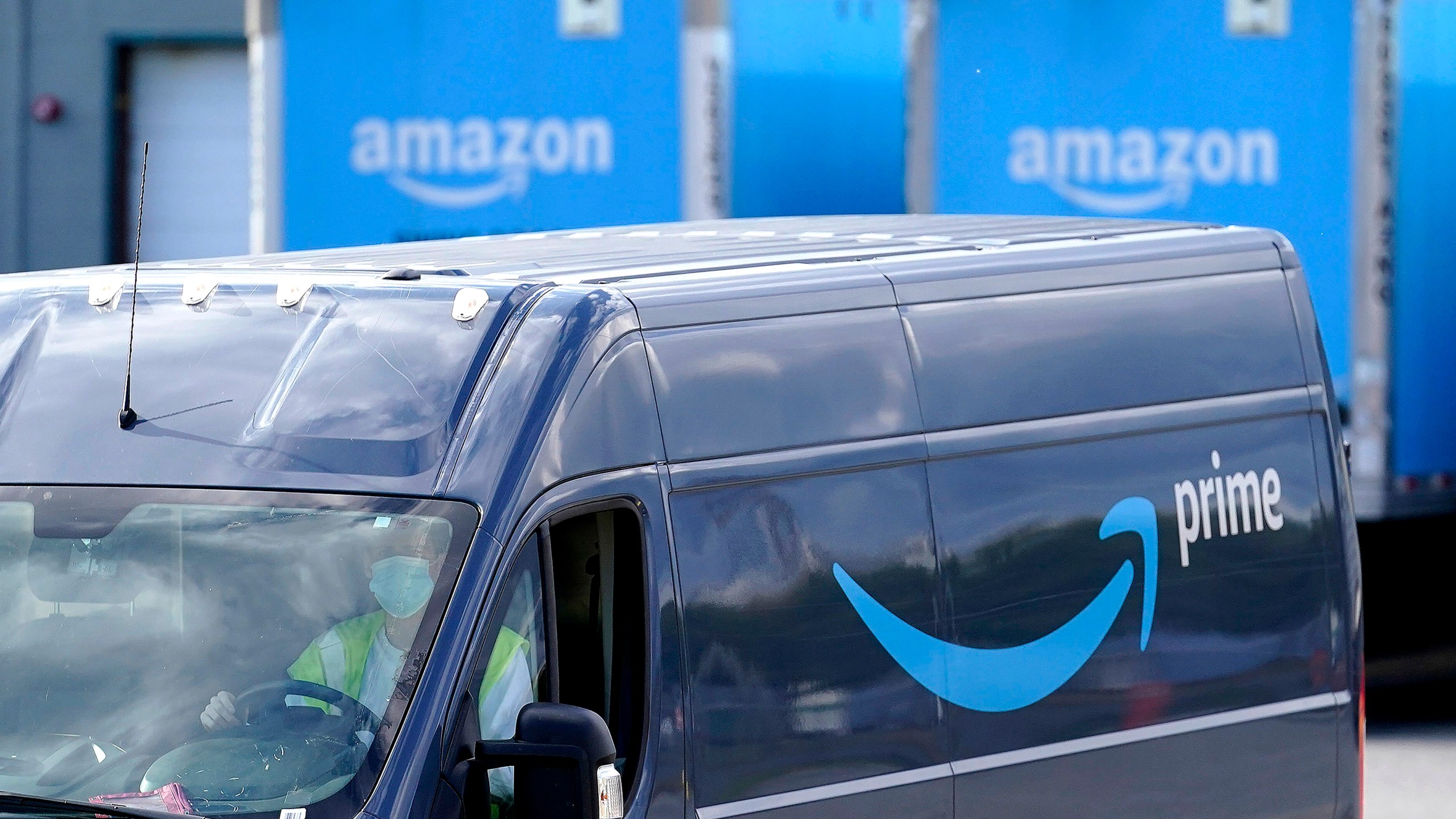 An Amazon Prime logo appears on the side of a delivery van as it departs an Amazon Warehouse location on Oct. 1, 2020, in Dedham, Mass. (Steven Senne / Associated Press)