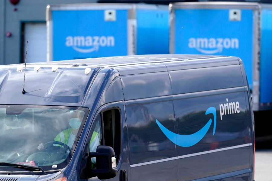 An Amazon Prime logo appears on the side of a delivery van as it departs an Amazon Warehouse location on Oct. 1, 2020, in Dedham, Mass. (Steven Senne / Associated Press)