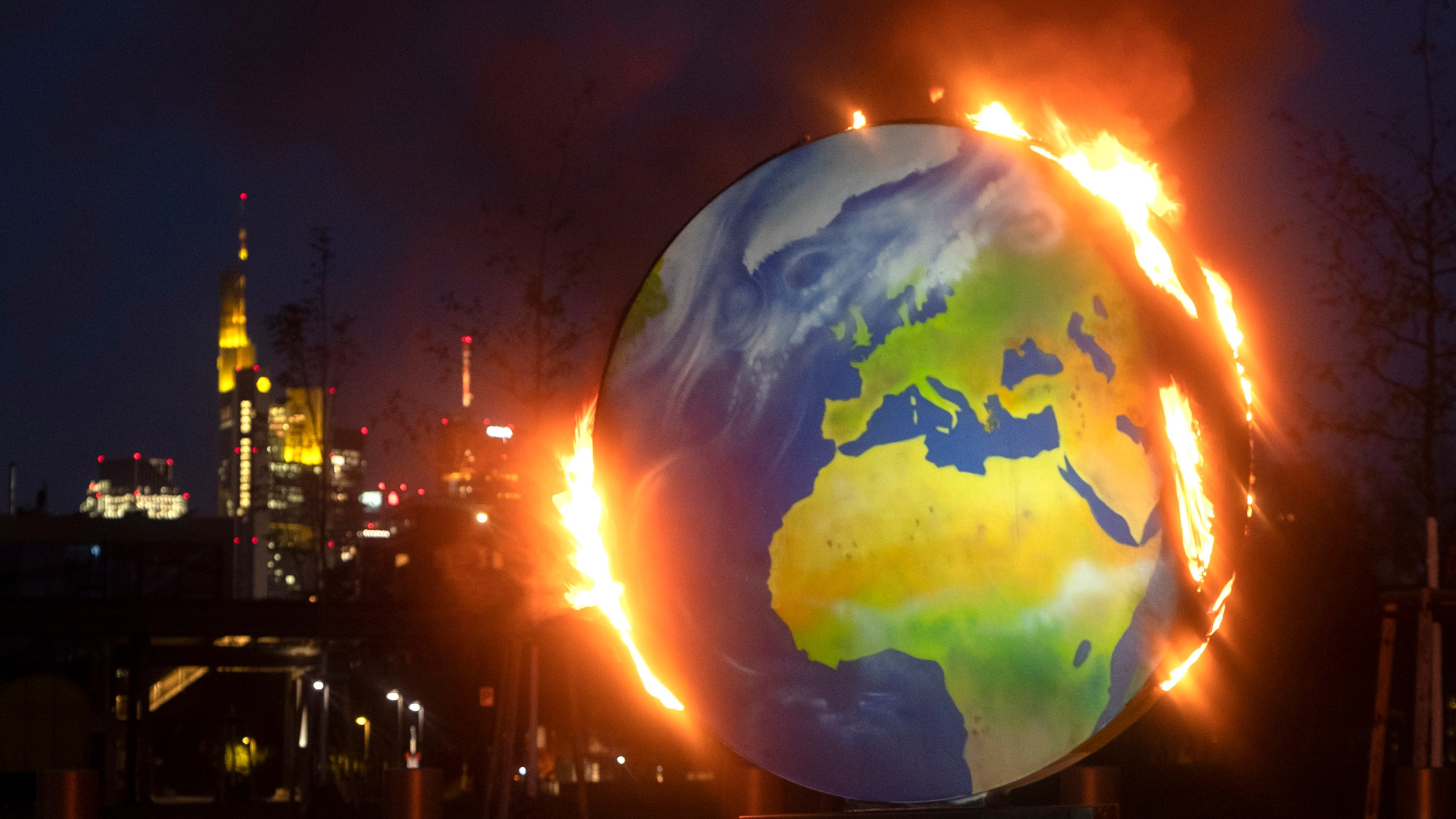 A makeshift globe burns in front of the European Central Bank in Frankfurt, Germany, Wednesday, Oct. 21, 2020. (AP Photo/Michael Probst)