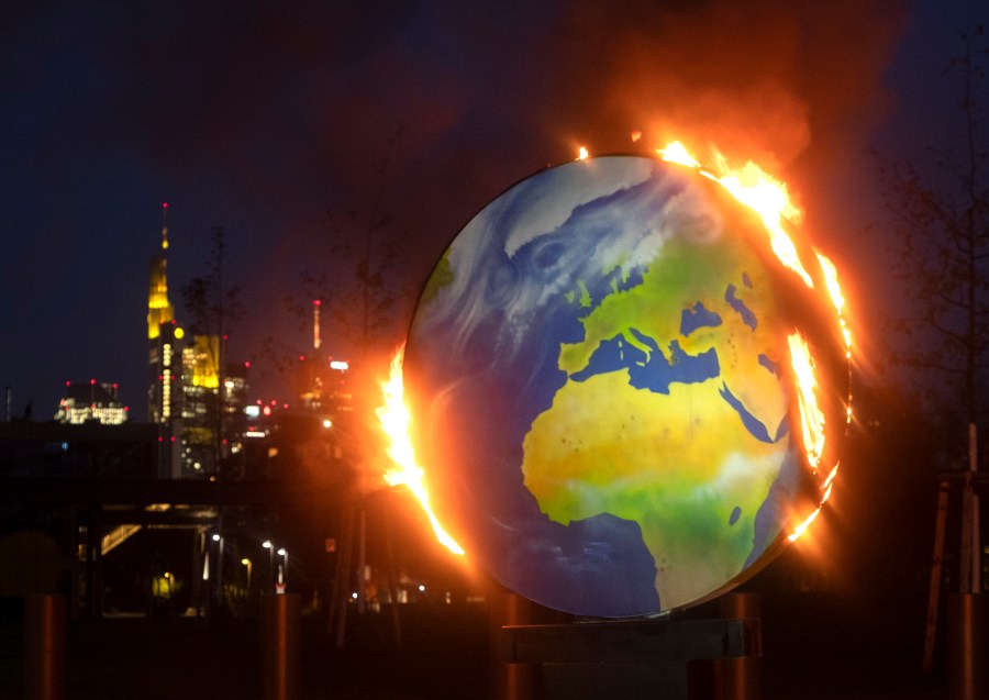 A makeshift globe burns in front of the European Central Bank in Frankfurt, Germany, Wednesday, Oct. 21, 2020. (AP Photo/Michael Probst)