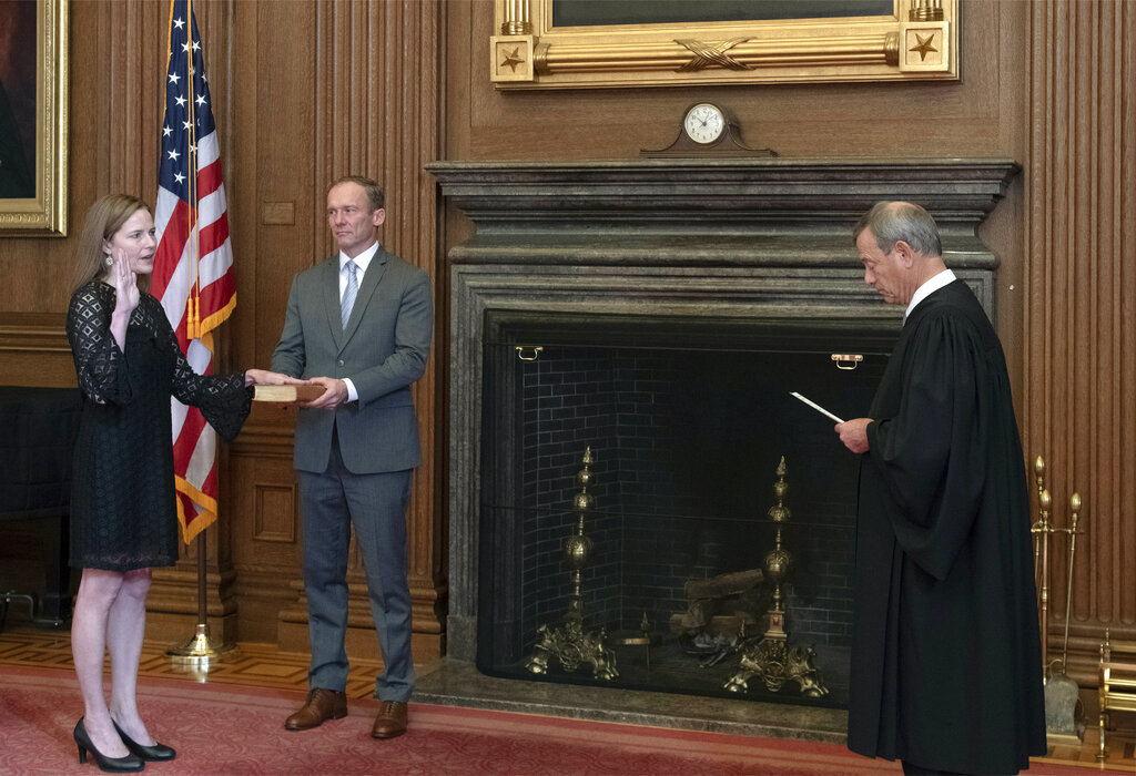 In this image provided by the Collection of the Supreme Court of the United States, Chief Justice John G. Roberts, Jr., right, administers the Judicial Oath to Judge Amy Coney Barrett, Tuesday, Oct. 27, 2020, in Washington. (Fred Schilling/Collection of the Supreme Court of the United States via AP)