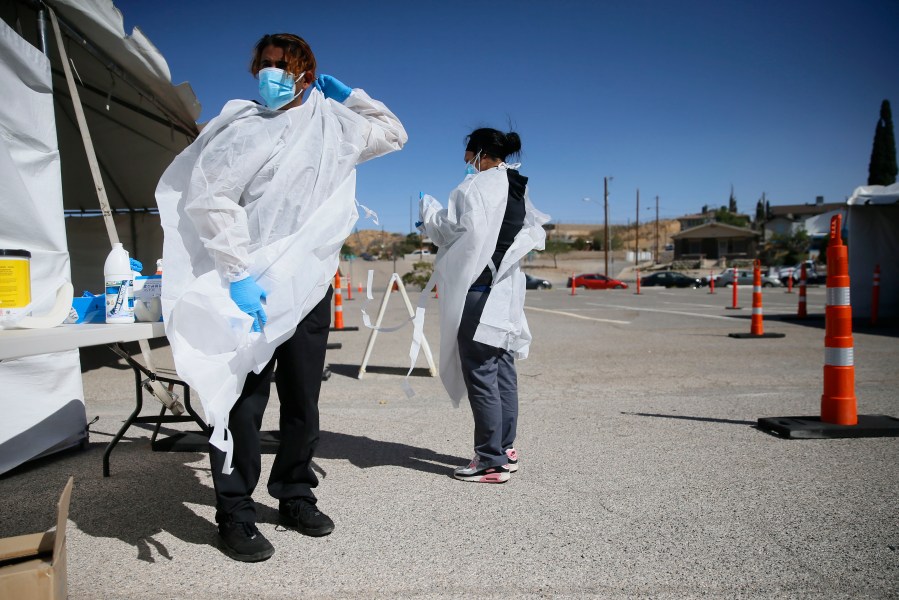 In this Oct. 26, 2020, file photo, Jacob Newberry puts on new PPE at the COVID-19 state drive-thru testing location at UTEP in El Paso, Texas. (Briana Sanchez/The El Paso Times via AP, File)