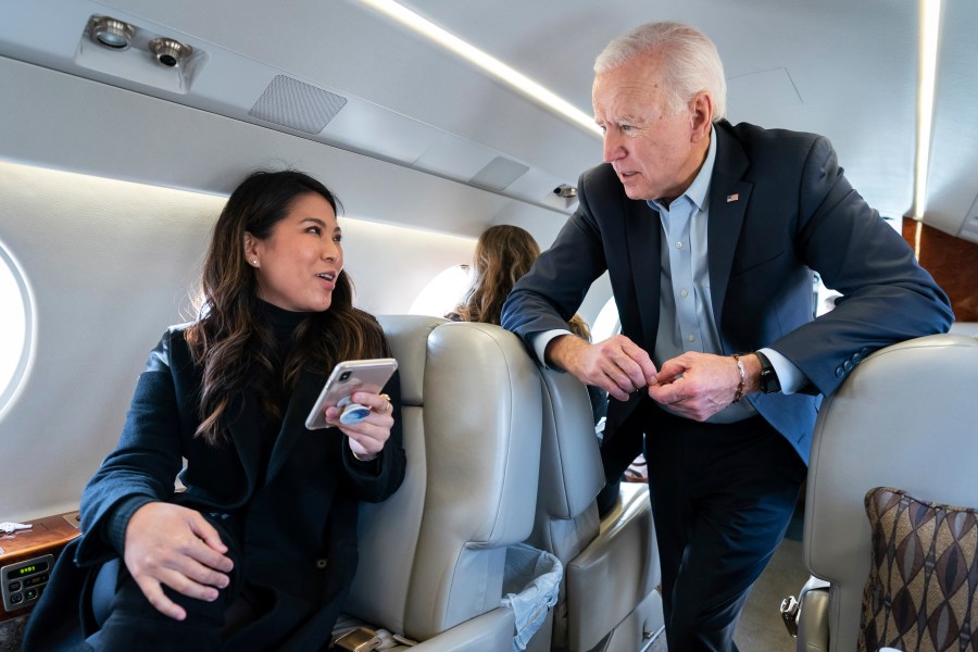 In this photo taken in November 2019, former Vice President Joe Biden speaks with his traveling national press secretary, Remi Yamamoto, on a flight to South Carolina. (Adam Schultz / Biden for President via Associated Press)