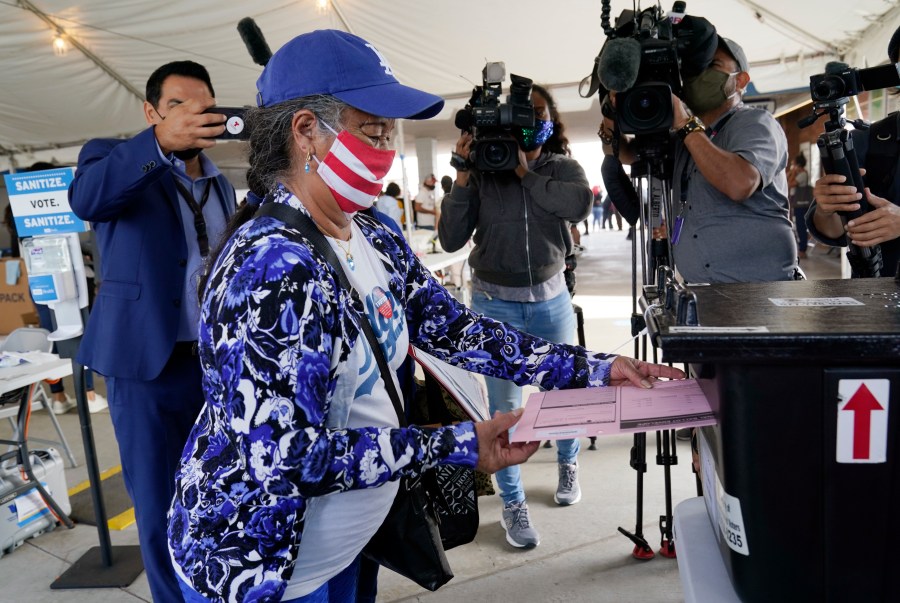 First-time voter Salvadora Martir, 73, turns in her ballot on Election Day at Dodger Stadium, Tuesday, Nov. 3, 2020, in Los Angeles. (AP Photo/Chris Pizzello)