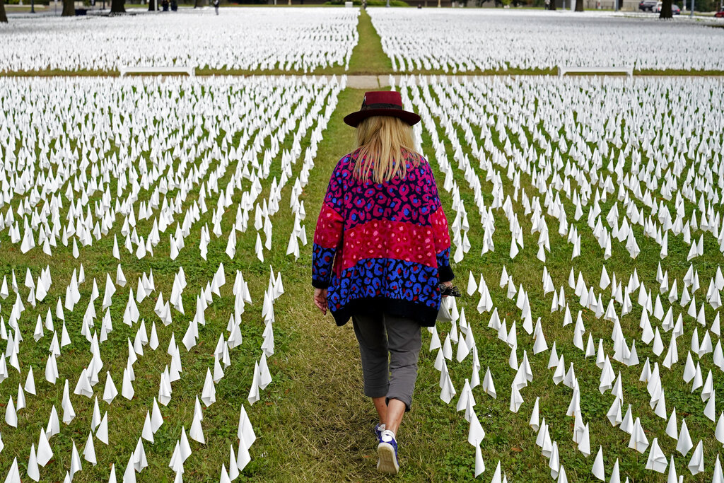 Artist Suzanne Brennan Firstenberg walks among thousands of white flags planted in remembrance of Americans who have died of COVID-19 near Robert F. Kennedy Memorial Stadium in Washington on Oct. 27, 2020. (AP Photo/Patrick Semansky, File)