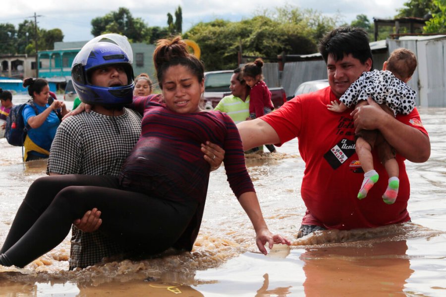 A pregnant woman is carried out of an area flooded by water brought by Hurricane Eta in Planeta, Honduras, Thursday, Nov. 5, 2020. (AP Photo/Delmer Martinez)